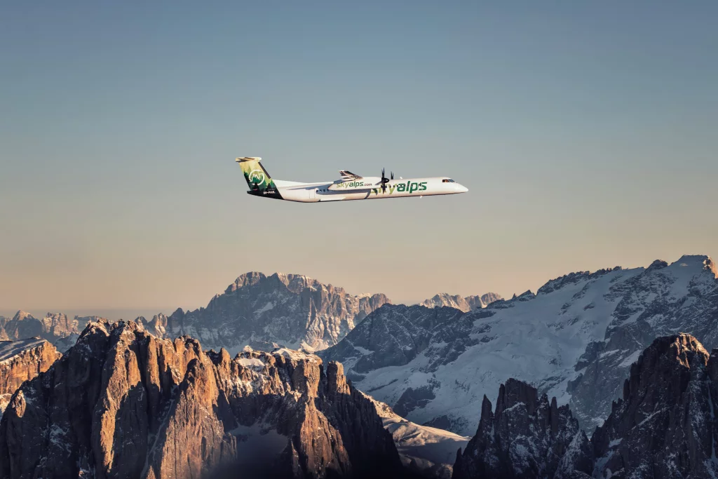 Un Dash 8-400 de SkyAlps survole les Dolomites. © SkyAlps